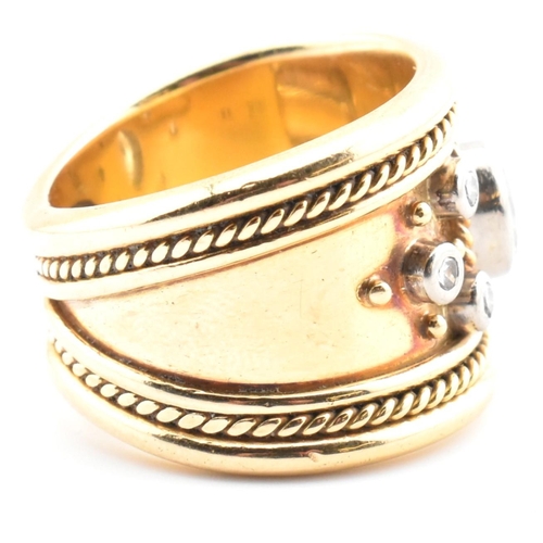 16 - An Etruscan style 18ct gold and diamond band ring. The 18ct yellow gold band ring having a principal... 