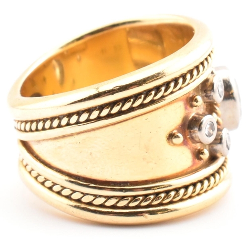 16 - An Etruscan style 18ct gold and diamond band ring. The 18ct yellow gold band ring having a principal... 