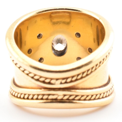 16 - An Etruscan style 18ct gold and diamond band ring. The 18ct yellow gold band ring having a principal... 