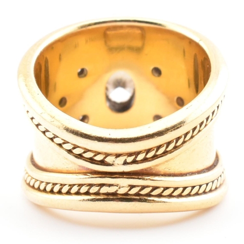 16 - An Etruscan style 18ct gold and diamond band ring. The 18ct yellow gold band ring having a principal... 