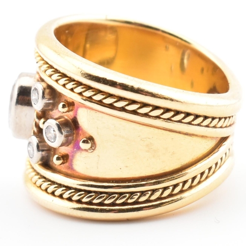 16 - An Etruscan style 18ct gold and diamond band ring. The 18ct yellow gold band ring having a principal... 