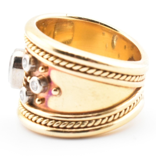 16 - An Etruscan style 18ct gold and diamond band ring. The 18ct yellow gold band ring having a principal... 