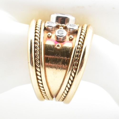 16 - An Etruscan style 18ct gold and diamond band ring. The 18ct yellow gold band ring having a principal... 