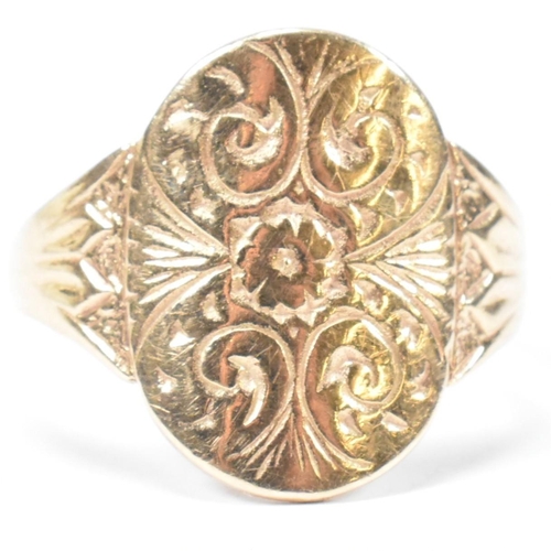 162 - A hallmarked 9ct gold engraved shield ring. The ring having a central oval shaped shield engraved wi... 