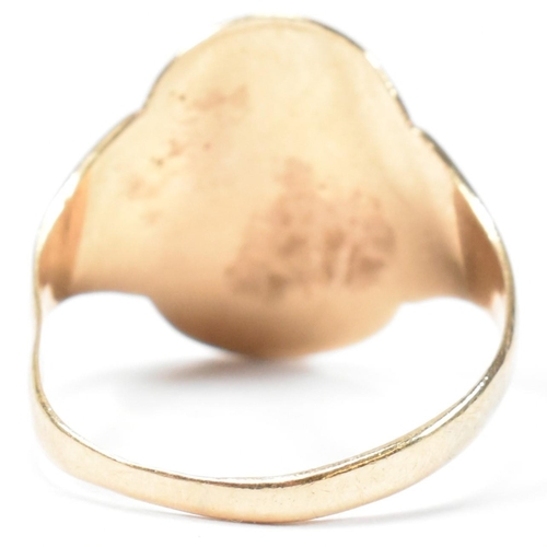 162 - A hallmarked 9ct gold engraved shield ring. The ring having a central oval shaped shield engraved wi... 