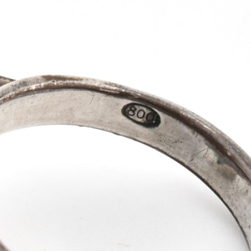 24 - A mid-century modernist 800 silver ring. The ring having a roundel top with articulating cup to plai... 