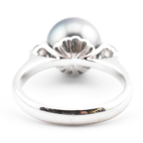 32 - An 18ct white gold, Tahitian pearl and diamond three stone ring. The 18ct white gold ring having a c... 