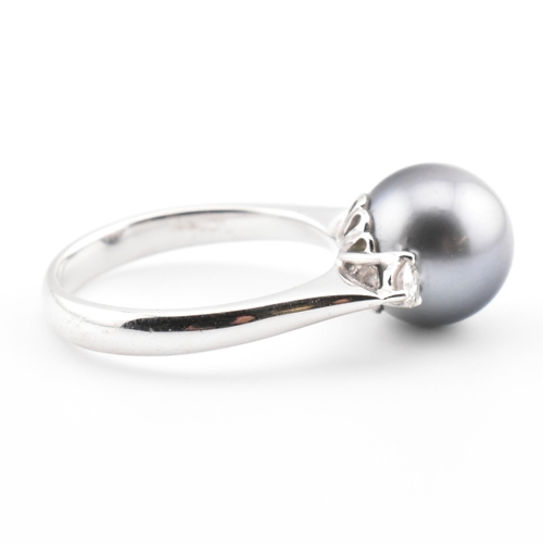 32 - An 18ct white gold, Tahitian pearl and diamond three stone ring. The 18ct white gold ring having a c... 