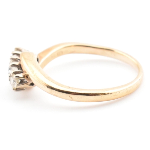 37 - A 9ct gold and diamond three stone crossover ring. The 9ct yellow gold ring having three round brill... 