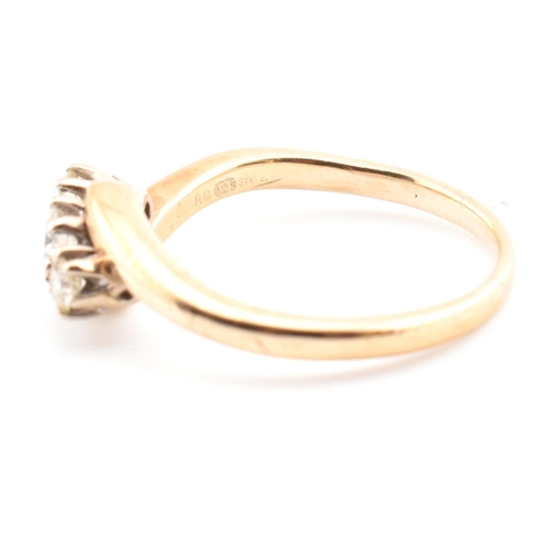 37 - A 9ct gold and diamond three stone crossover ring. The 9ct yellow gold ring having three round brill... 