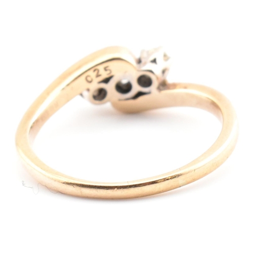 37 - A 9ct gold and diamond three stone crossover ring. The 9ct yellow gold ring having three round brill... 