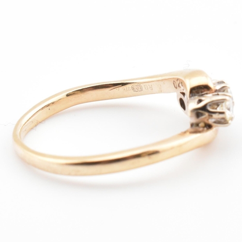 37 - A 9ct gold and diamond three stone crossover ring. The 9ct yellow gold ring having three round brill... 