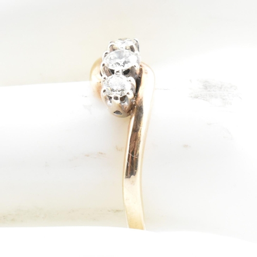 37 - A 9ct gold and diamond three stone crossover ring. The 9ct yellow gold ring having three round brill... 