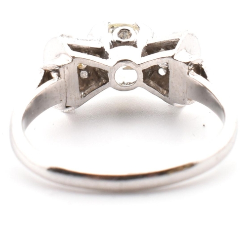 38 - A platinum Art Deco diamond ring. The antique ring in the form of a bow having a centre transitional... 