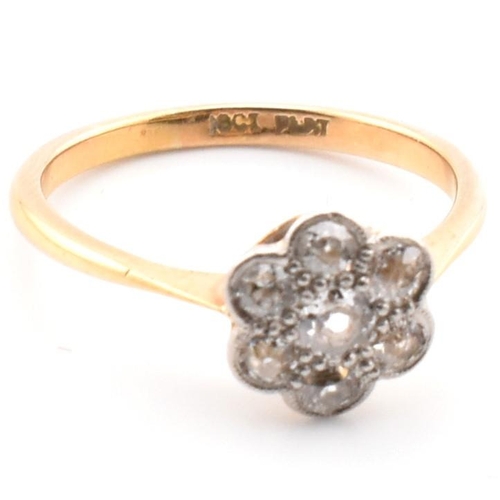 40 - A 1920s 18ct gold and platinum diamond flower cluster ring. The antique ring having a central old cu... 