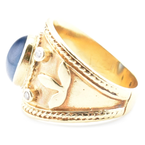 41 - An Etruscan style gold, sapphire and diamond band ring. The ring having a central collet set oval sa... 