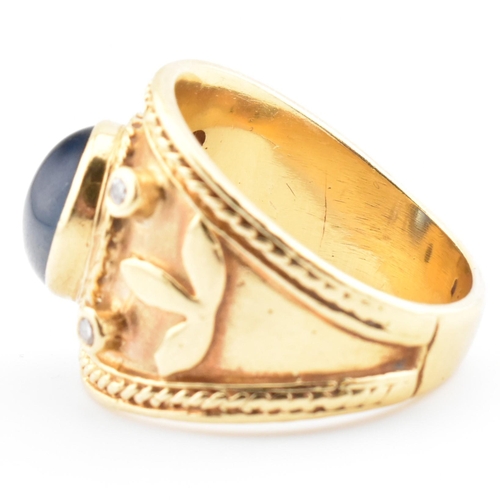 41 - An Etruscan style gold, sapphire and diamond band ring. The ring having a central collet set oval sa... 