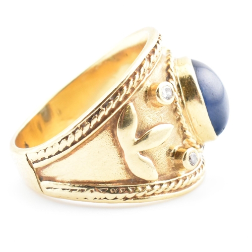 41 - An Etruscan style gold, sapphire and diamond band ring. The ring having a central collet set oval sa... 