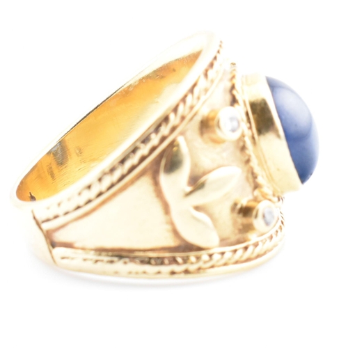 41 - An Etruscan style gold, sapphire and diamond band ring. The ring having a central collet set oval sa... 