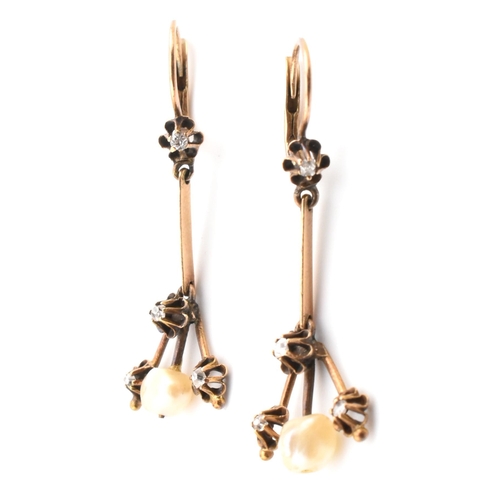 44 - A pair of antique gold pearl and diamond pendant earrings. The antique pendant earrings set with a p... 