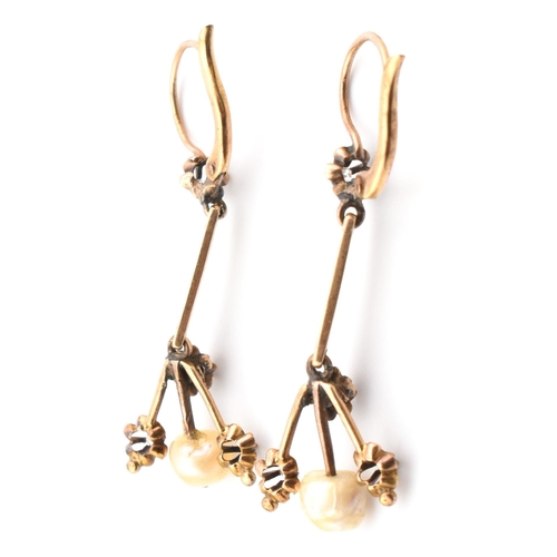 44 - A pair of antique gold pearl and diamond pendant earrings. The antique pendant earrings set with a p... 