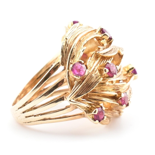 48 - A hallmarked 9ct gold and ruby leaf bombe ring. The hallmarked 9ct yellow gold ring of pierced, over... 