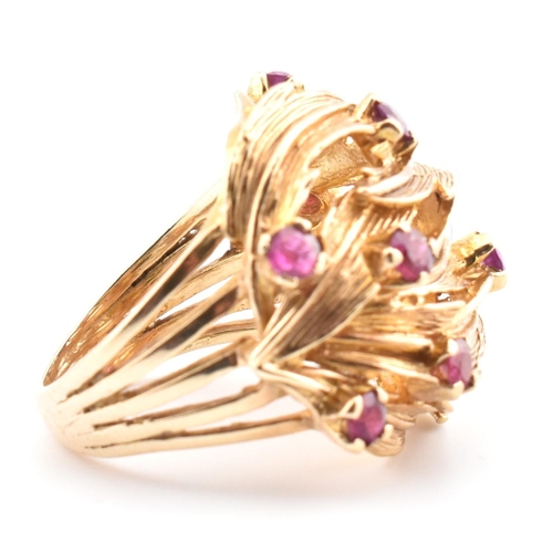 48 - A hallmarked 9ct gold and ruby leaf bombe ring. The hallmarked 9ct yellow gold ring of pierced, over... 