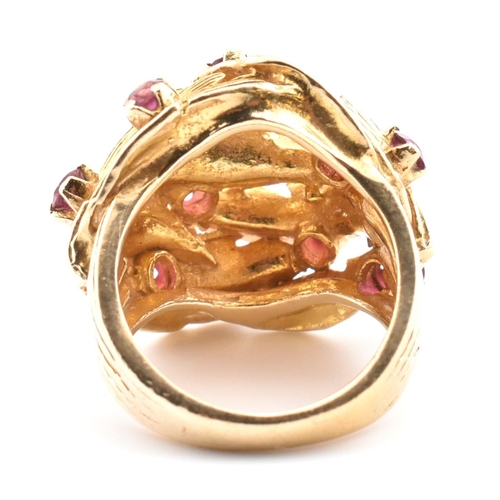 48 - A hallmarked 9ct gold and ruby leaf bombe ring. The hallmarked 9ct yellow gold ring of pierced, over... 