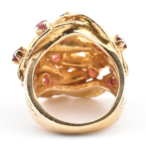 48 - A hallmarked 9ct gold and ruby leaf bombe ring. The hallmarked 9ct yellow gold ring of pierced, over... 