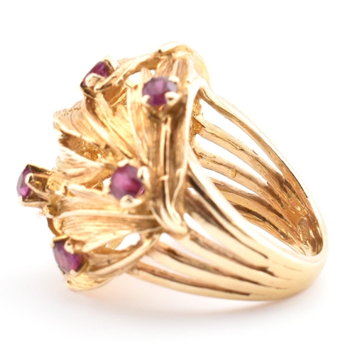 48 - A hallmarked 9ct gold and ruby leaf bombe ring. The hallmarked 9ct yellow gold ring of pierced, over... 