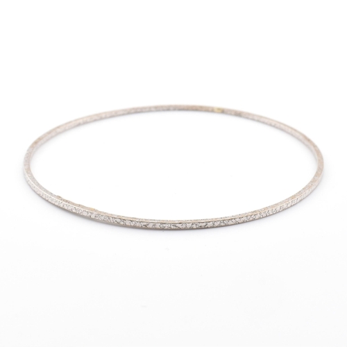 51 - An Italian 14ct white gold bangle. The white gold bangle having a textured finish. Marked 14ct to in... 