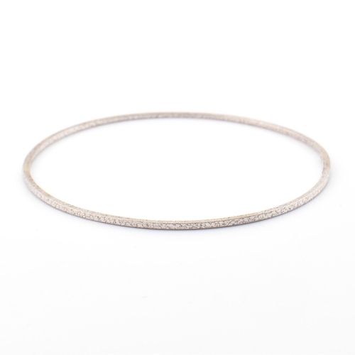 51 - An Italian 14ct white gold bangle. The white gold bangle having a textured finish. Marked 14ct to in... 