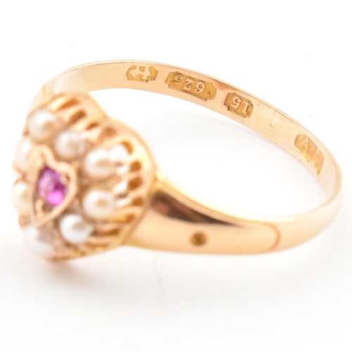 55 - A Victorian hallmarked 15ct gold, ruby and pearl heart ring. The ring set with a central round cut r... 