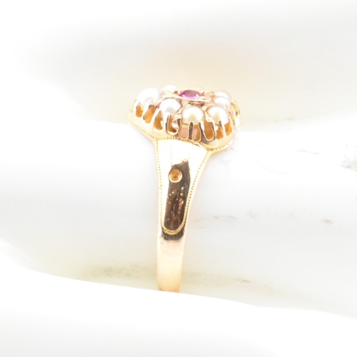 55 - A Victorian hallmarked 15ct gold, ruby and pearl heart ring. The ring set with a central round cut r... 