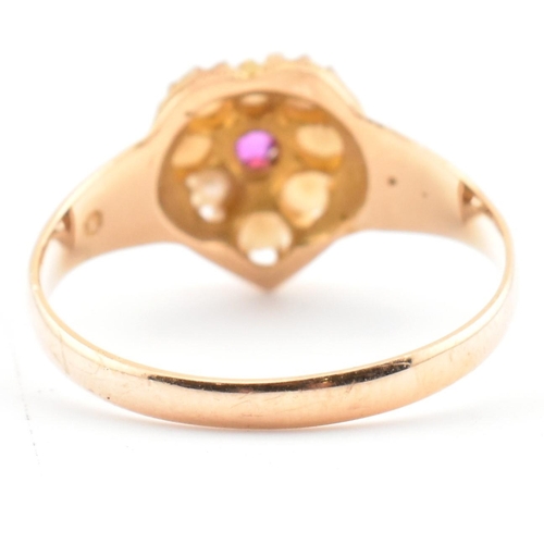 55 - A Victorian hallmarked 15ct gold, ruby and pearl heart ring. The ring set with a central round cut r... 