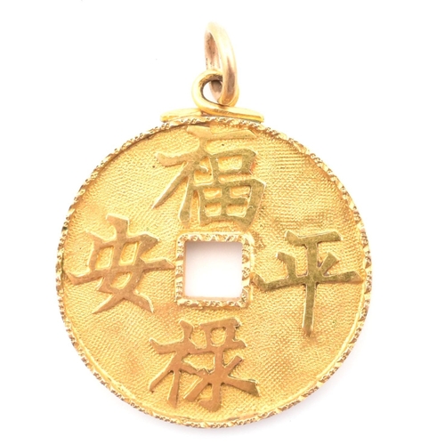 56 - An 18ct gold Chinese coin necklace pendant. The 18ct yellow gold pierced coin pendant having four Ch... 