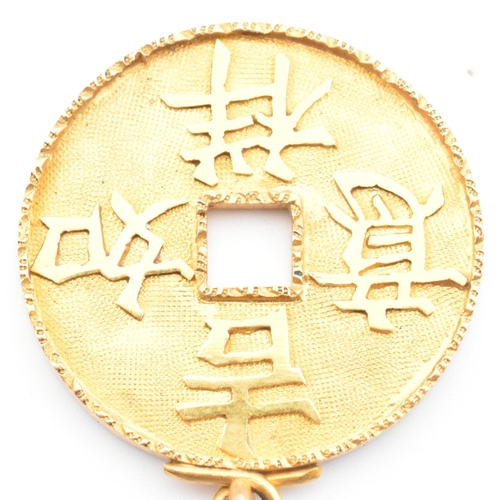 56 - An 18ct gold Chinese coin necklace pendant. The 18ct yellow gold pierced coin pendant having four Ch... 