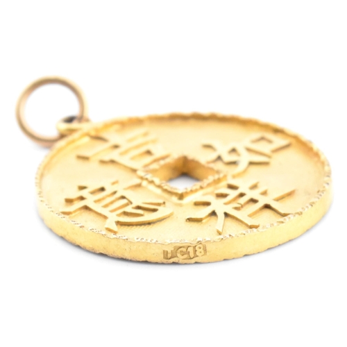 56 - An 18ct gold Chinese coin necklace pendant. The 18ct yellow gold pierced coin pendant having four Ch... 