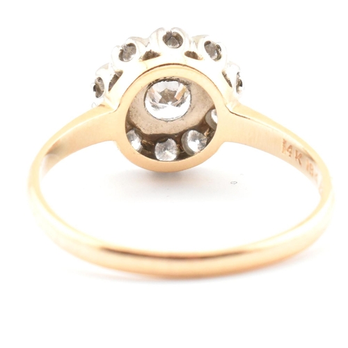 67 - A gold and diamond cluster ring. The ring having a central round brilliant cut diamond surrounded by... 