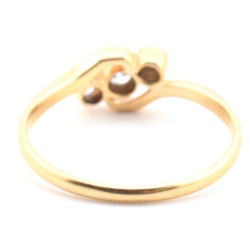 68 - A cased 18ct gold and diamond three stone crossover ring. The 18ct yellow gold ring having three gra... 