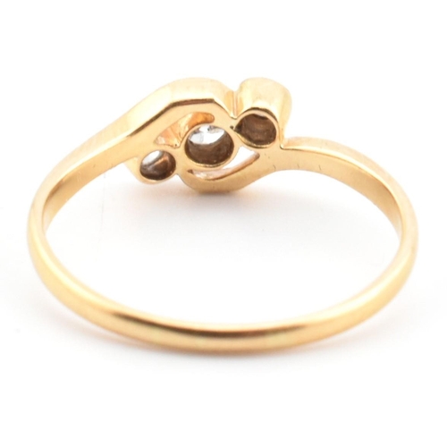 68 - A cased 18ct gold and diamond three stone crossover ring. The 18ct yellow gold ring having three gra... 