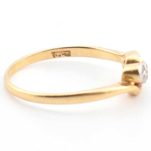 68 - A cased 18ct gold and diamond three stone crossover ring. The 18ct yellow gold ring having three gra... 