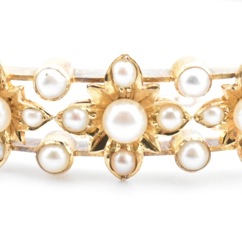 7 - An antique 15ct gold and pearl hinged bangle. The yellow gold hinged bangle having five graduating g... 