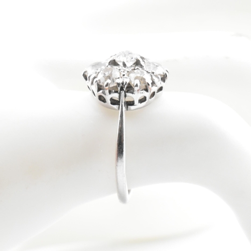 70 - A platinum and diamond seven stone cluster ring. The ring set with seven round cut diamonds in a clu... 