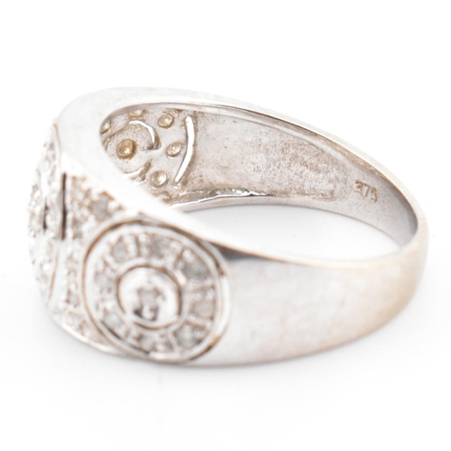 74 - A hallmarked 9ct white gold and diamond ring. The 9ct white gold domed ring having three circles set... 