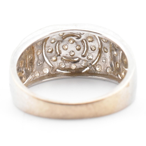 74 - A hallmarked 9ct white gold and diamond ring. The 9ct white gold domed ring having three circles set... 