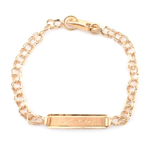 75 - A gold christening bracelet with name plate. The gold double curb link christening bracelet having a... 