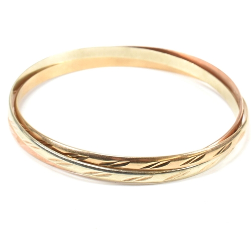 76 - A hallmarked 9ct gold tri-colour Russian bangle. The bangle comprised of three tri-colour gold inter... 