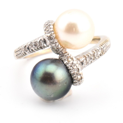 77 - An 18ct gold, cultured pearl and diamond crossover ring. The ring having two cultured pearls set in ... 