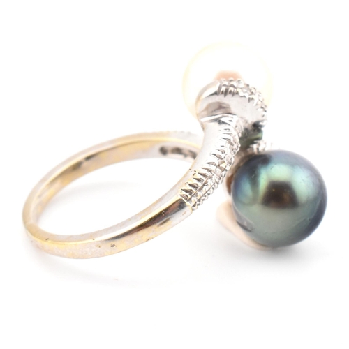 77 - An 18ct gold, cultured pearl and diamond crossover ring. The ring having two cultured pearls set in ... 